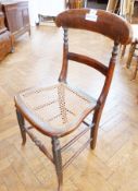 An antique cane seated chair, with carved backrail to cane seat, on turned supports, united by