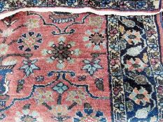 Persian-style wool rug, the maroon ground decorated with vases of flowers, running floral borders,