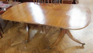 Georgian-style mahogany double-pedestal dining table having curved ends, cross banded top on