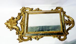 Reproduction giltwood mirror with ornate scroll carved frame