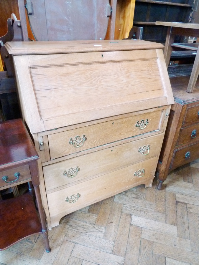 Early 20th century oak bureau, with hinged fall-front, enclosing an assortment of pigeonholes and