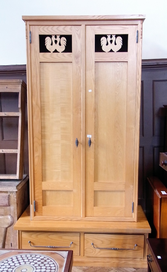 A modern light hardwood double wardrobe, with carved and pierced panel doors decorated with