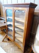 A late Victorian walnut dwarf glazed bookcase, with pair of doors enclosing five shelves, on