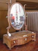 A mahogany swing frame toilet mirror, oval, on box base with three drawers, bone handles and