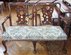 A Chippendale-style mahogany two-seater sofa of double chair style, each back with foliate scroll