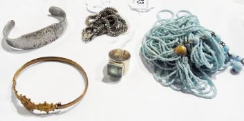 A silver ring with square-set green-coloured stone, a turquoise beaded necklace, a silver-coloured