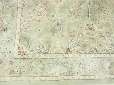 A Beluchi silk carpet, made in Belgium, green ground with cream border decorated with  flowers,
