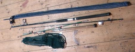 Three fishing rods, cane fishing basket containing reels, nets and accessories