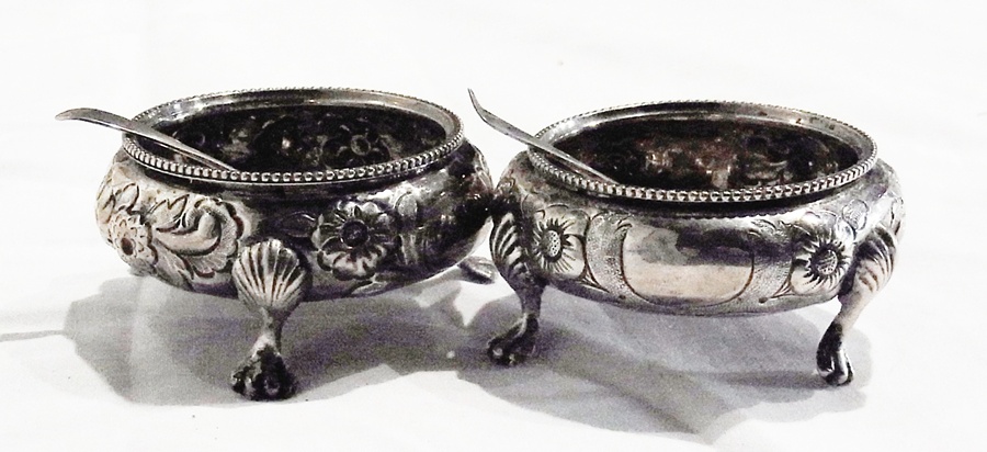 Pair Victorian silver and parcel-gilt circular salts with floral decoration on paw feet with