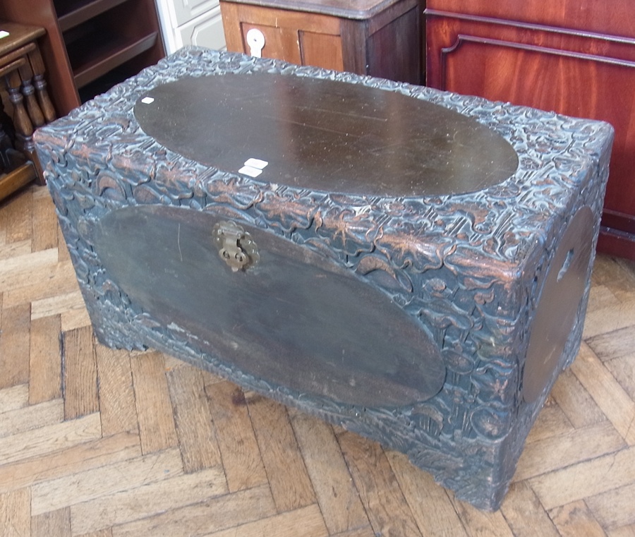 A heavily floral carved Eastern chest, with plain oval panels, raised on bracket feet, width 170cms