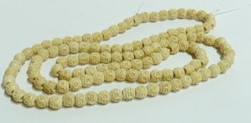 String of bone beads flowerhead decorated