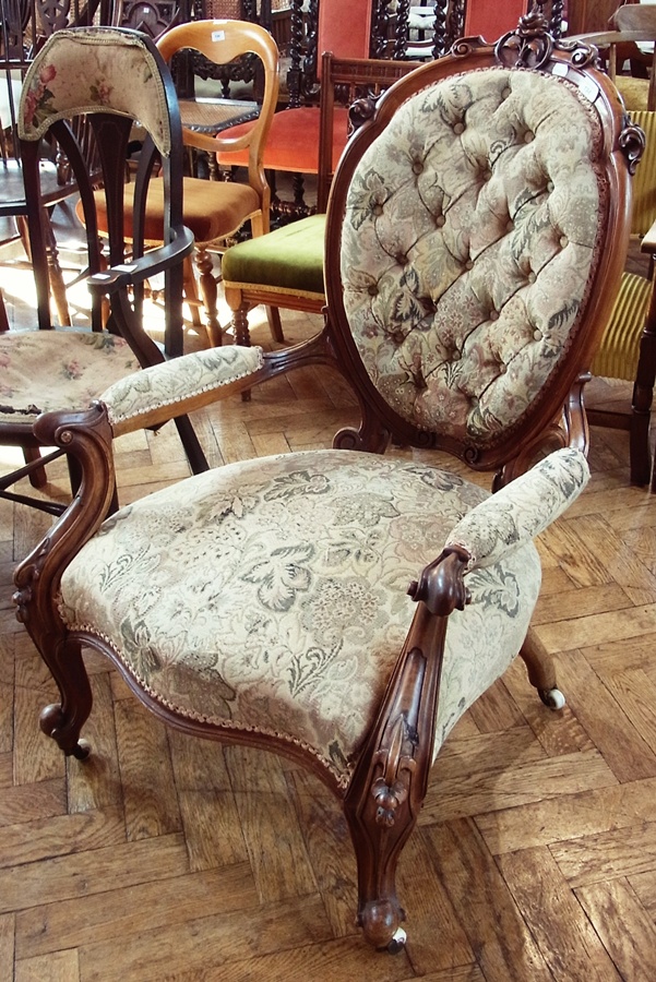 Victorian walnut open arm drawing room chair, with shaped oval back, relief carved with rose and