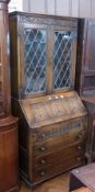 A reproduction carved oak glazed bureau bookcase, with scroll carved frieze, the pair of leaded