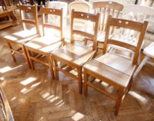 Set of four hardwood dining chairs each with curved toprail and crossrail, panel seat on straight