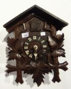 Old Swiss carved wood cuckoo clock of typical form and applied with vine leaves, 37cm high