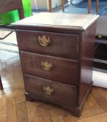 Small oak bedside chest with quadrant mould edge, three drawers with brass drop handles and shaped