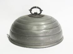 Set of three graduated pewter meat domes, oval and ribbed, with loop handles