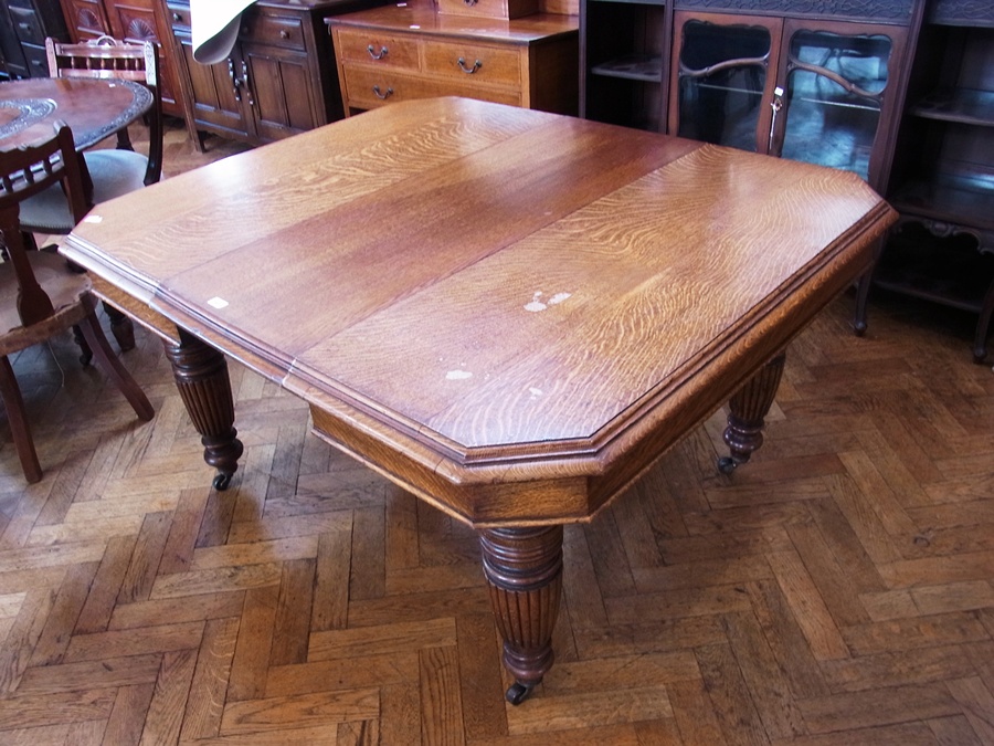 Victorian oak extending dining table, rectangular with cut-off corners having quadrant mould edge on