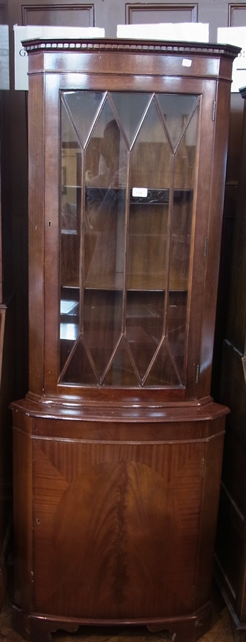 A reproduction mahogany bow-fronted astragal glazed corner cupboard, the astragal glazed door