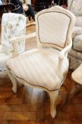 A French style open armchair painted in cream with padded back and seat on cabriole supports