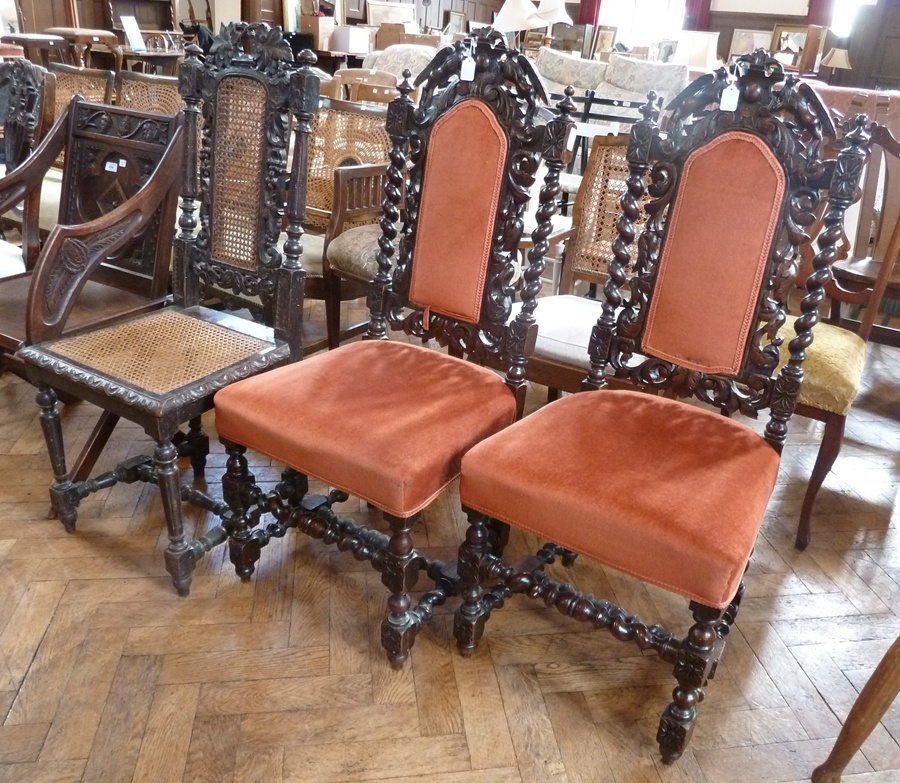 Pair Carolean style carved oak dining chairs each carved with two birds, flanking the raised