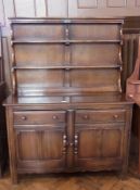 Mid twentieth century oak dresser with open shelf plate rack, two frieze drawers with pair of