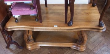 A rectangular-top coffee table, with moulded wavy edge, on carved legs with shelf below, 120cm long