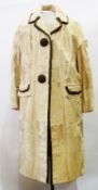 A 1970's cream ponyskin coat with brown suede trim to collar, pockets, two large brown suede