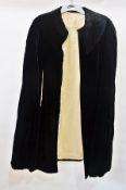 A late 19th century black velvet cape with stitched collar and cream satin lining