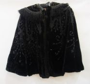 A Victorian black velvet cape, heavily embroidered with faux jet beads and ribbon detail, fringing