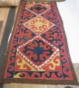 A Turkish felt rug, with yellow, red and blue lozenge medallions with conforming border, 318 x 138