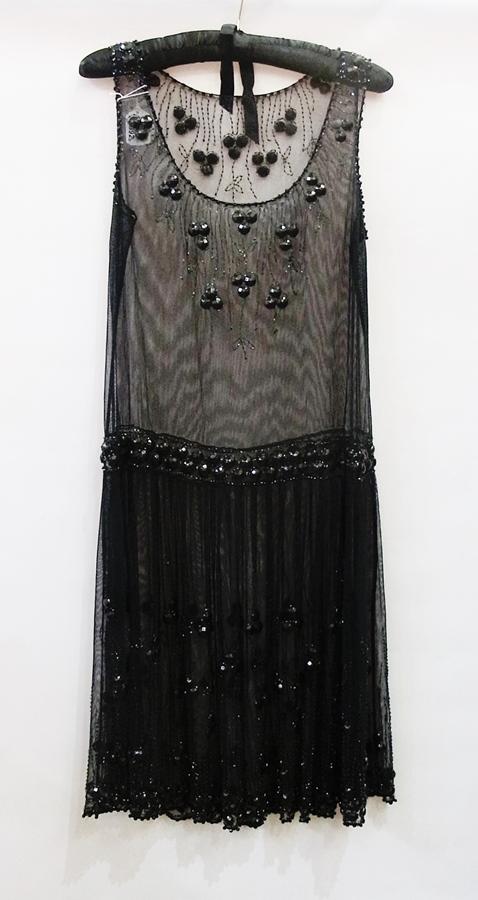 A 1920's style black net dress, drop-waist, heavily decorated with faux jet
