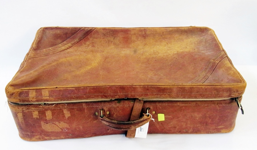 A vintage leather suitcase, rather worn with one or two travel labels