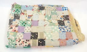 A patchwork quilted bed throw, another quilted throw decorated with flowers and a white bed throw (