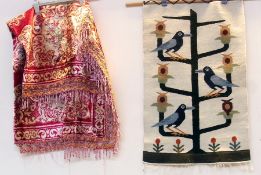 A silk rug, red ground, with cream medallions, and a tapestry wall hanging depicting totem style