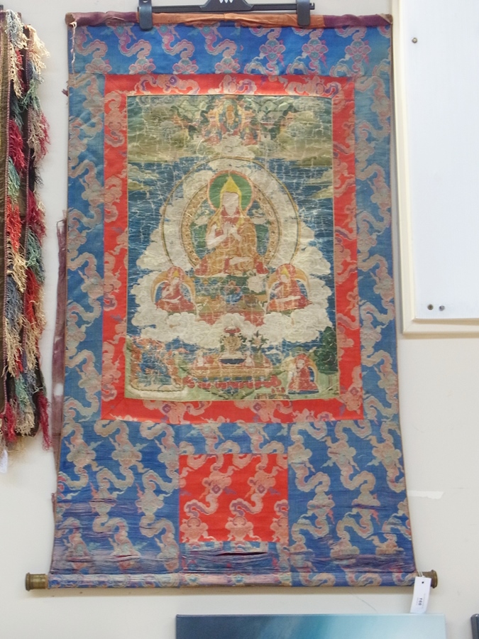 A 20th century Buddhist Thangka, blue and red panel border, with printed panel image of Buddha in