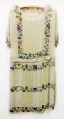 A 1920's sage coloured drop-waisted chiffon dress with multi-coloured decorations with bugle