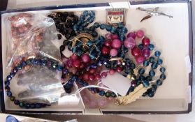 A quantity of costume jewellery to include glass beads, brooches and other items (1 box)