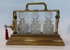 Victorian Betjemann's patent gilt metal and cut glass small tantalus, gilt metal stand, all-over