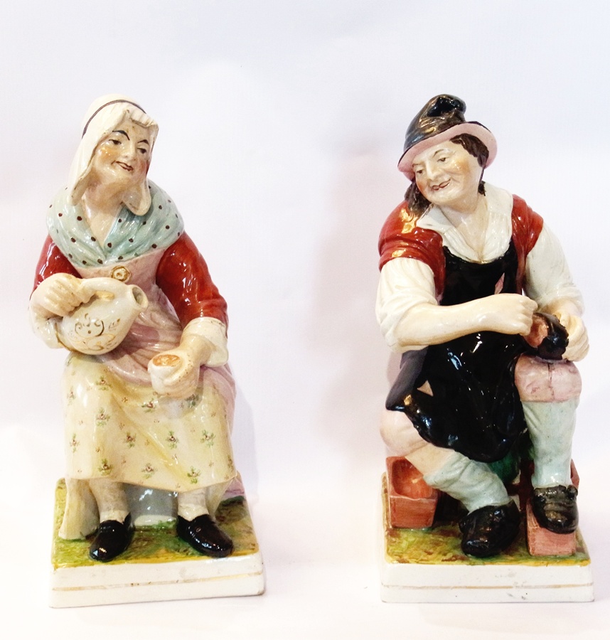 A pair of large 19th century Staffordshire figures of a cobbler and his wife, with overall