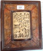 Oriental carved bone plaque in rectangular walnut frame, the carved concave plaque highly carved