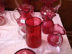 Two Victorian cranberry  and clear diamond panelled jugs with everted rims and two other cranberry