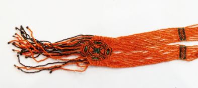 North American bead necklace, circa 1900-1930, in the form of multiple strands of orange beads,