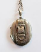 Late Victorian /Edwardian silver-coloured metal oval locket, with relief buckle decoration and