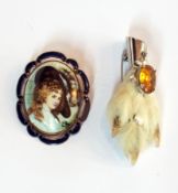 Ceramic portrait brooch decorated with head and shoulders of a lady, within blue enamel frame and