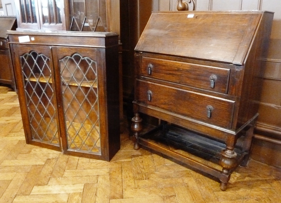 Oak bureau bookcase, the top section with leaded glazed panel doors, the bureau base with two long