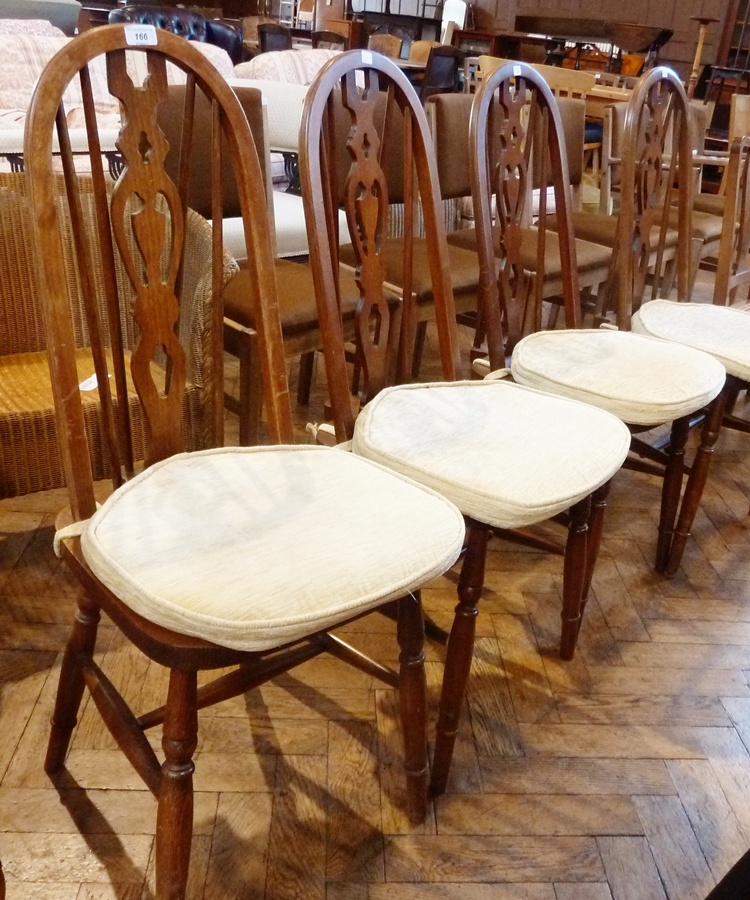 Set of four elm and hardwood ercol style dining chairs each with tall arch back, pierced central