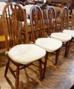 Set of four elm and hardwood ercol style dining chairs each with tall arch back, pierced central