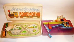 A modern tinplate train track, boxed, and a tinplate track with clockwork car, in purple box and a