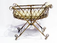 Victorian brass folding dolls pram, boat-shaped with rope, on brass X-frame supports united by